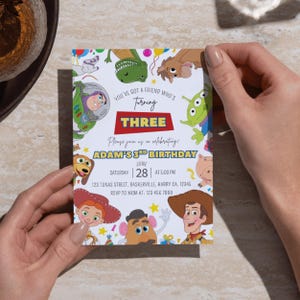 Op de afbeelding: Een rechthoekige verjaardagsuitnodigingskaart met kleurrijke stripfiguren, waaronder een space ranger, een cowboy, een cowgirl, een groene dinosaurus en een alien. De tekst luidt: You've got a friend who's turning three, Adam's 3rd birthday, June 28.
