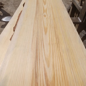 May include: Two unfinished, light-colored wooden planks with visible grain patterns. The planks are side by side, showing the natural wood texture and color variations. The wood appears to be freshly cut and ready for use in woodworking projects.