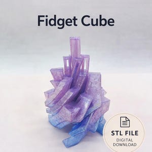 Puede incluir: Un cubo fidget impreso en 3D en tonos morados y azules, con un diseño geométrico complejo. El texto "Fidget Cube" está en la parte superior, y un icono de descarga digital con "STL FILE DIGITAL DOWNLOAD" está en la parte inferior derecha.