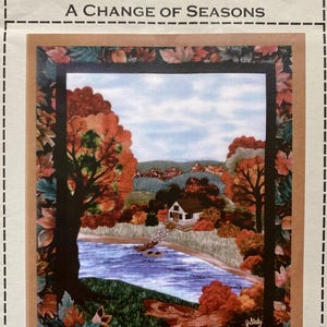May include: A quilt pattern titled "A Change of Seasons" featuring a colourful autumn scene with a small house, a lake, and trees. The pattern is by Joan's Own Creations.