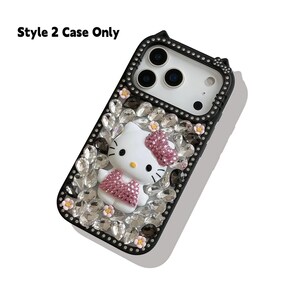 May include: Black phone case with a Hello Kitty design. The case features a white Hello Kitty figure with a pink bow and dress, surrounded by clear and black rhinestones. The text "Style 2 Case Only" is at the top.