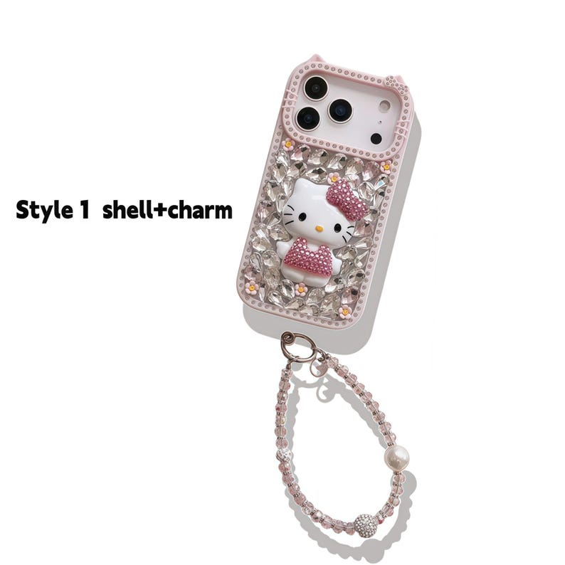 May include: Pink phone case with a Hello Kitty design, encrusted with rhinestones. The case has a matching wrist strap with pink beads, a pearl, and a rhinestone ball. The text "Style 1 shell+charm" is visible.