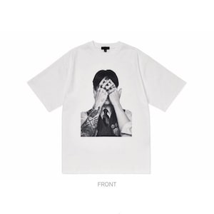 Puede incluir: Camiseta blanca de manga corta con un gr&aacute;fico en blanco y negro de una persona cubri&eacute;ndose los ojos. La persona lleva un chaleco y corbata. La palabra "FRONT" est&aacute; impresa en la parte inferior.