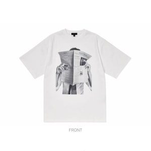 Puede incluir: Camiseta blanca de manga corta con un gr&aacute;fico en blanco y negro de una persona sosteniendo un peri&oacute;dico frente a su rostro. La camiseta tiene cuello redondo y un dise&ntilde;o sencillo. La palabra "FRONT" est&aacute; impresa en la parte inferior.