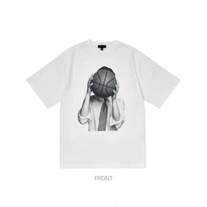 Puede incluir: Camiseta blanca de manga corta con un gr&aacute;fico en blanco y negro de una persona sosteniendo una pelota de baloncesto frente a su rostro. La persona lleva camisa y corbata blancas. La palabra "FRONT" est&aacute; impresa en la parte inferior.