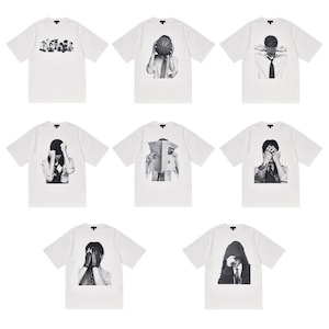 May include: A collection of white t-shirts featuring black and white graphic designs. The designs include images of people covering their faces with hands, a basketball, and a newspaper. The shirts have short sleeves and a crew neck.