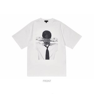 Puede incluir: Camiseta blanca con un gr&aacute;fico en blanco y negro de una persona con los ojos vendados y corbata. La palabra "FRONT" est&aacute; impresa en la parte inferior de la camiseta.