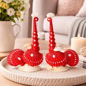 May include: A white ceramic mug with a black handle and the text "But First, Coffee" in a black, bold font. The mug is on a white surface.