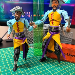 May include: Two articulated pirate action figures with light blue sleeves, yellow vests, black pants, and purple sashes. They wear grey tricorn hats and hold small silver knives. A green Westcott ruler stands between them, showing heights of 6 and 8 inches.