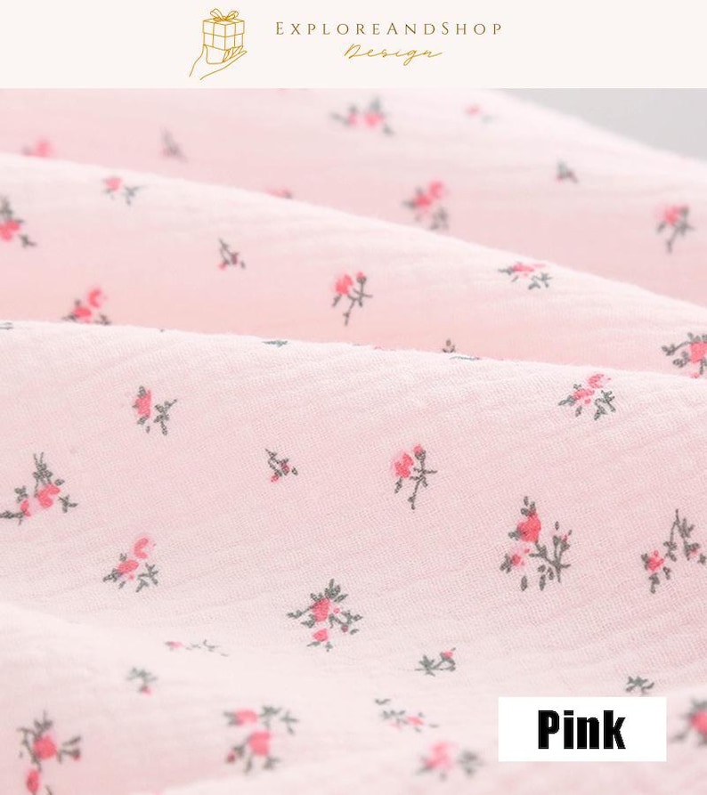 May include: Close-up of pink fabric with a delicate floral pattern. The fabric is a light pink color, with small red and green floral designs scattered across the surface. The word "Pink" is in a white rectangle.