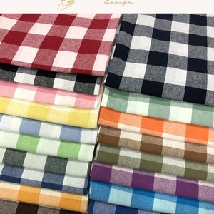 May include: A collection of folded fabric squares featuring a classic gingham check pattern in a variety of colors including red, black, pink, yellow, blue, green, orange, brown, purple, and teal, stacked in two neat vertical columns.