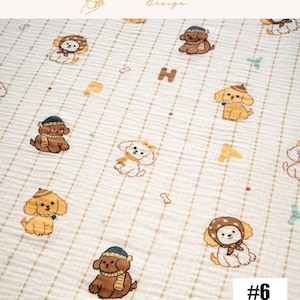 May include: A cream-colored fabric with a repeating pattern of cartoon dogs wearing hats and scarves. The dogs are brown, tan, and white. The fabric also features the letters "H" and "A", along with bone and crossbone shapes. The text "#6" is in the bottom right corner.
