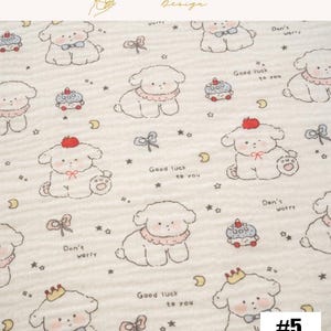 May include: Cream-colored fabric with a repeating pattern of cartoon dogs, cupcakes, bows, stars, and moons. The dogs have different accessories, including bows, crowns, and collars. Text includes "Good luck to you" and "Don't worry". The number "#5" is in the bottom right corner.