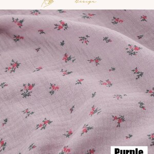 May include: Close-up of a purple fabric with a floral pattern. The fabric has a textured appearance and is covered with small, red and green floral designs. The word "Purple" is displayed in a white box in the bottom right corner.