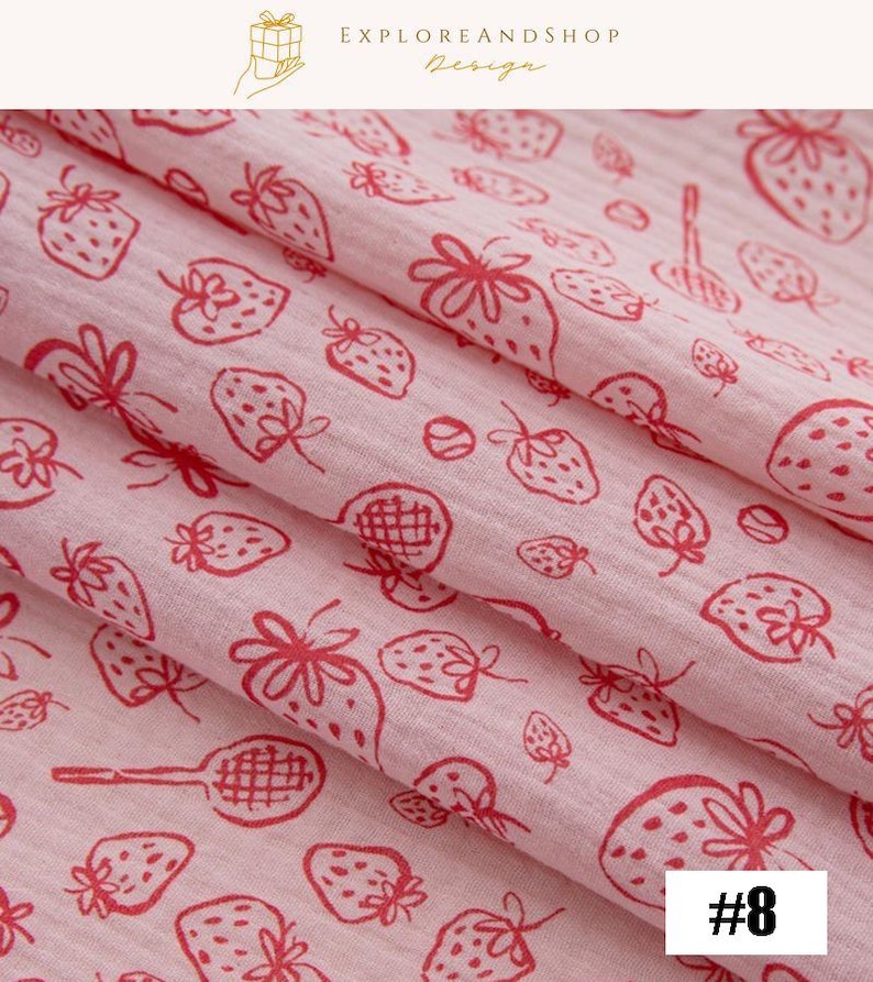May include: Pink fabric with a repeating pattern of red strawberries and tennis rackets. The fabric is folded, showing the texture and design. The text "#8" is in the bottom right corner. The words "EXPLOREANDSHOP Design" are at the top.