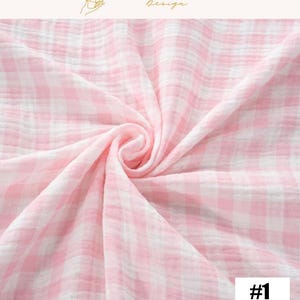 May include: A close-up of a pink and white gingham fabric. The fabric is soft and textured, with a swirling pattern. The text "#1" is in the bottom right corner. The top of the image has the text "EXPLOREANDSHOP Design".