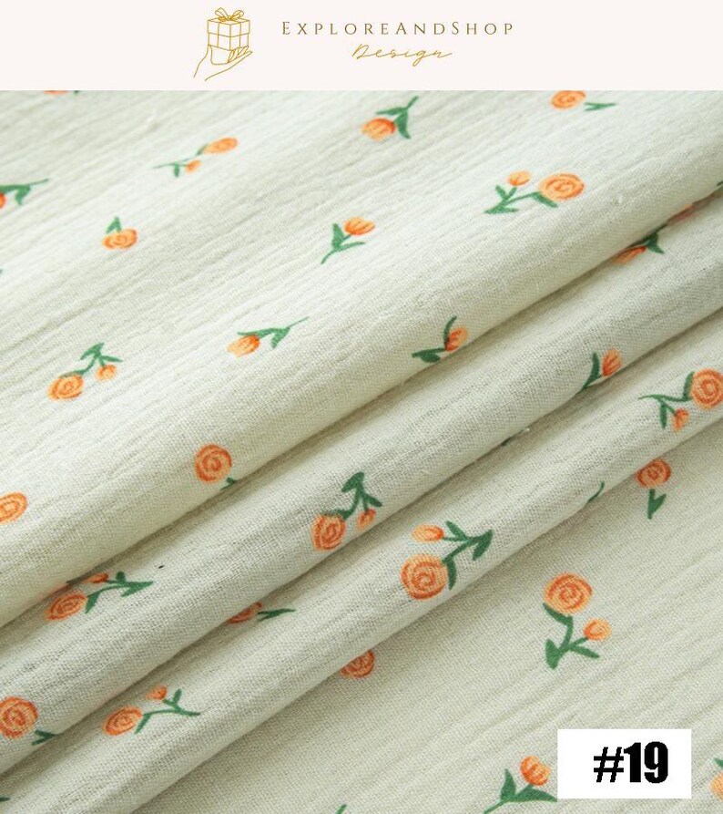 May include: Cream-colored fabric with a repeating pattern of orange roses and green leaves. The fabric is folded, showing its texture and design. The text "EXPLOREANDSHOP Design" is at the top, and the number "#19" is in the bottom right corner.