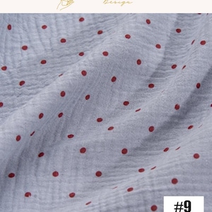 May include: Close-up of a light blue fabric with a crinkled texture, adorned with evenly spaced, dark red polka dots. The fabric is slightly wrinkled, creating subtle shadows. The number "#9" is in the bottom right corner.