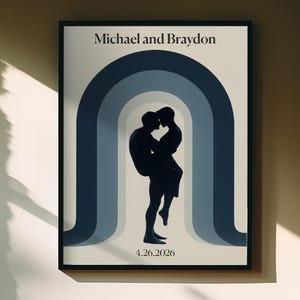 Könnte beinhalten: Gerahmter Kunstdruck mit einer Silhouette von zwei sich umarmenden Personen vor einem Hintergrund aus blauen Bögen. Die Namen "Michael und Braydon" stehen oben, das Datum "4.26.2026" unten. Schwarzer Rahmen.
