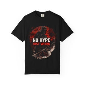 May include: Black t-shirt with a samurai warrior graphic. The design features the text "NO HYPE JUST WORK" in white and red. The samurai is illustrated in a dark, detailed style against a red and white background.