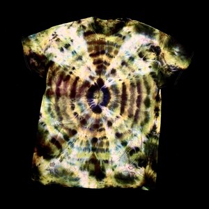 May include: A tie-dye t-shirt with a spiral pattern in shades of yellow, green, brown, and blue. The shirt has a crew neck and short sleeves. The tie-dye design is centered on the front of the shirt.