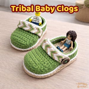 May include: Two green crochet baby clogs with a tribal design on the strap. The clogs have a beige trim and a button closure. The text "Tribal Baby Clogs" is displayed at the top. One clog has a Lego figure inside.