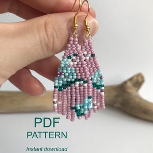 May include: Handmade beaded fringe earrings in a brick stitch pattern. The earrings feature a design with pink, teal, white, and dark green beads. Gold-colored ear wires complete the design. The text "PDF PATTERN" is visible in the image.