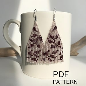 May include: A pair of triangular beaded earrings featuring a light beige background with a dark maroon abstract pattern. The earrings hang from silver-toned metal hooks. The text PDF PATTERN Instant download is visible.