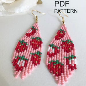 Può includere: Un paio di orecchini di perline a forma di goccia con un motivo a fragole nei toni del rosa, rosso, bianco e verde, con accenti dorati e ganci dorati. Il testo "Instant download PDF PATTERN" è visibile nell'angolo in alto a destra.