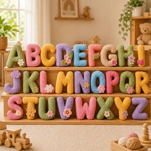 May include: A complete set of twenty-six alphabet letters made from crocheted yarn in various colors including green, pink, yellow, purple, blue, and tan. Each letter is decorated with small, hand-stitched fabric flowers or a heart.