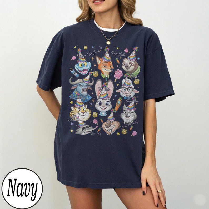 May include: Navy blue t-shirt featuring a colorful graphic of cartoon animal characters wearing party hats. The design includes a variety of animals, such as a fox, sloth, and bunny, with the text "Happy Birthday" and "Nick Wilde".