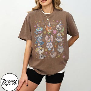 May include: Brown t-shirt featuring cartoon characters in party hats. The shirt has the text "Do Good, Not With" and the brand name "Espersso" in a circle on the bottom left.
