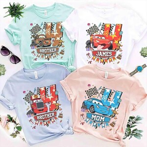 K&ouml;nnte beinhalten: Vier kurz&auml;rmelige T-Shirts in Hellgr&uuml;n, Wei&szlig;, Hellblau und Hellrosa. Jedes zeigt eine gro&szlig;e Zahl Vier, eine Rennwagen-Figur, Zielflaggen und den Text BROTHER, JAMES, BROTHER oder MOM zusammen mit verschiedenen Geburtstagsparty-Grafiken.