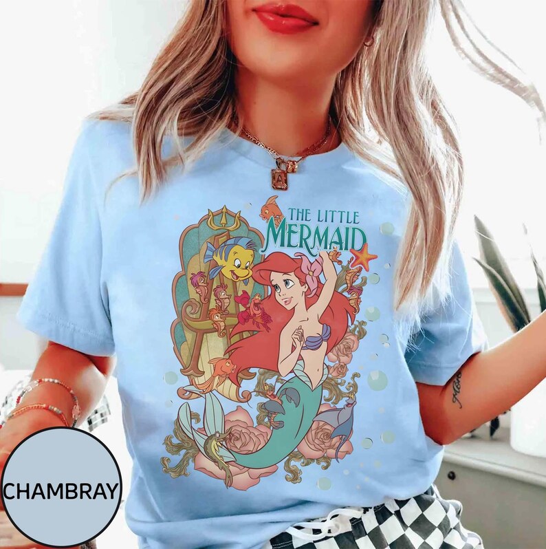 Pu&ograve; includere: T-shirt azzurro con grafica di Ariel de La Sirenetta, con la scritta "THE LITTLE MERMAID". Il design include Ariel, Flounder ed elementi floreali. La maglietta &egrave; realizzata in materiale morbido.