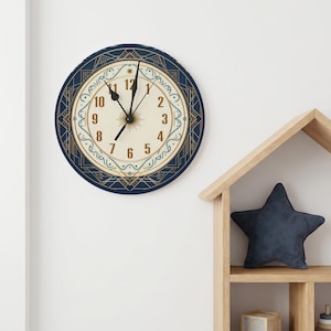 Könnte beinhalten: Eine runde Wanduhr mit cremefarbenem Zifferblatt und goldenen Ziffern von eins bis zwölf. Die Uhr hat schwarze Zeiger und ist von einem dunkelblauen, kreisförmigen Rahmen umgeben, der mit komplexen geometrischen Linien in Gold und Türkis verziert ist.
