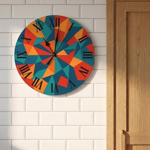 May include: A round wall clock featuring a geometric pattern of triangles in shades of blue, orange, and red. The clock face displays black Roman numerals from I to XII arranged in a circle, with two black hands indicating the current time.