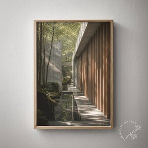 May include: A framed wall art print featuring a modern architectural structure with vertical wooden slats and concrete walls. The scene includes a narrow water feature reflecting the surrounding trees and mossy rocks under soft, natural sunlight.