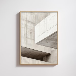 Puede incluir: Una impresión enmarcada que presenta una composición arquitectónica abstracta. La imagen muestra estructuras de hormigón en tonos grises y blancos, creando una estética moderna y minimalista. La obra de arte está encerrada en un marco de madera natural.