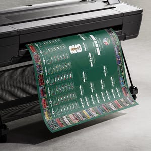May include: A large-format printer printing a green poster with a soccer tournament bracket. The poster features team logos and match details. The printer is black and gray, and the poster is emerging from the machine.