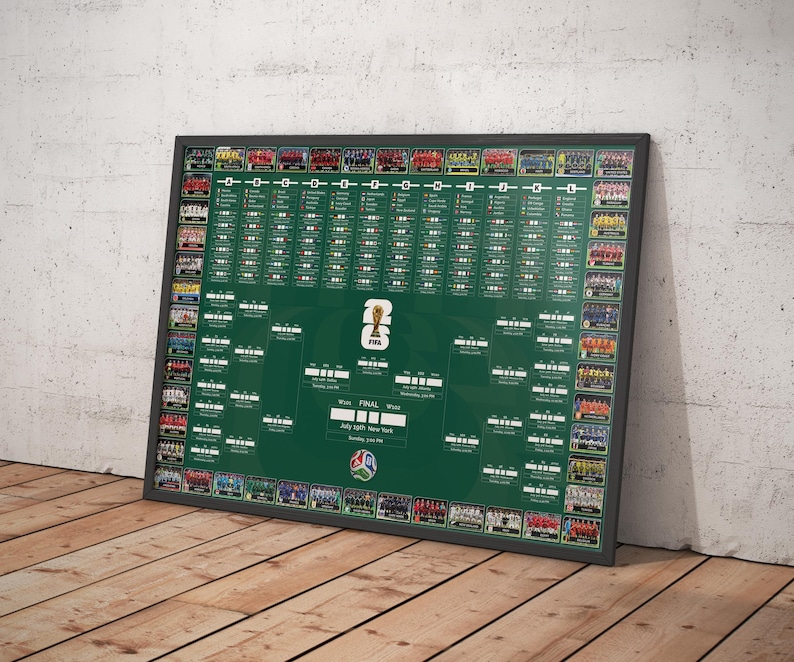 May include: A framed green poster featuring a FIFA World Cup bracket. The poster has a black frame and is leaning against a wall. Team photos are displayed around the bracket, with the FIFA logo at the bottom. The poster is on a wooden floor.