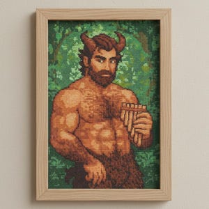 May include: Framed cross-stitch art featuring a muscular satyr with brown fur, horns, and a beard, holding a pan flute. The background is a green forest scene. The artwork is in a light-colored wooden frame.
