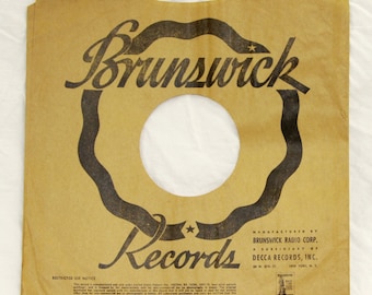 May include: A brown paper record sleeve with a black and white Brunswick Records logo. The sleeve has a star and the text "Manufactured by Brunswick Radio Corp. A subsidiary of Decca Records, Inc. 30 W. 37th St. New York, N.Y."