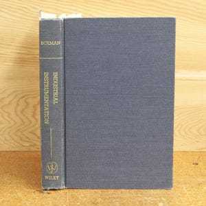 May include: A navy blue hardcover book titled "Industrial Instrumentation" by Eckman, published by Wiley.