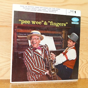 May include: Vintage vinyl record album cover featuring the musical duo "pee wee" & "fingers." The cover art showcases two men, one in a striped suit and straw hat, the other in a vest and hat, with a trombone and piano. The album is labeled "Part 1."