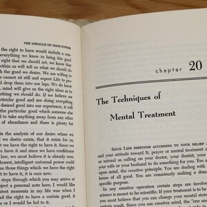Op de afbeelding: Open boek met tekst op de pagina's. De titel "The Techniques of Mental Treatment" wordt weergegeven. Hoofdstuk 20 is zichtbaar. Het boek ligt open op een houten oppervlak.