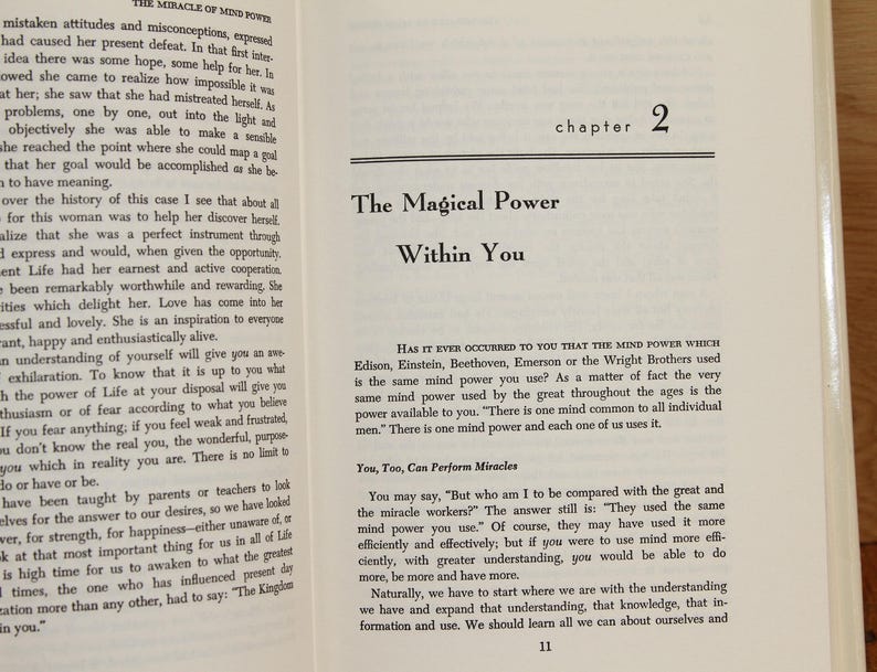 Op de afbeelding: Open boek met de titel "The Magical Power Within You" op een cr&egrave;mekleurige pagina. Hoofdstuk 2 is zichtbaar. De tekst gaat over de kracht van de geest.