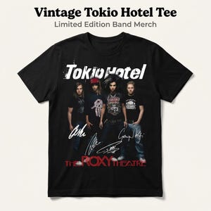 May include: Black t-shirt featuring the band Tokio Hotel with the band's name in white. The shirt includes the text "Vintage Tokio Hotel Tee" and "Limited Edition Band Merch" at the top, and "The Roxy Theatre" at the bottom, with signatures.