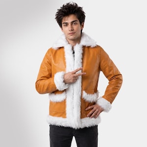 Könnte beinhalten: Hellbraune Lederjacke mit weißem Kunstfellbesatz an Kragen, Manschetten und Taschen. Die Jacke hat ein klassisches Design mit Knopfverschluss und ein weiches, strukturiertes Aussehen. Das Model trägt eine schwarze Jeans.