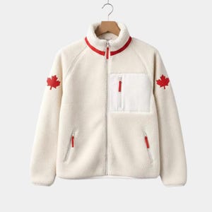 May include: Cream-colored fleece jacket with a red maple leaf emblem on the left sleeve and a white pocket with a red zipper. The jacket has a red trim around the collar and a full-length zipper.