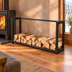 Peut inclure: Un porte-bûches rectangulaire en métal noir au design ouvert, rempli d'une pile de bûches fendues de couleur claire. Le support présente une base robuste et des montants verticaux, offrant une solution de rangement structurée.